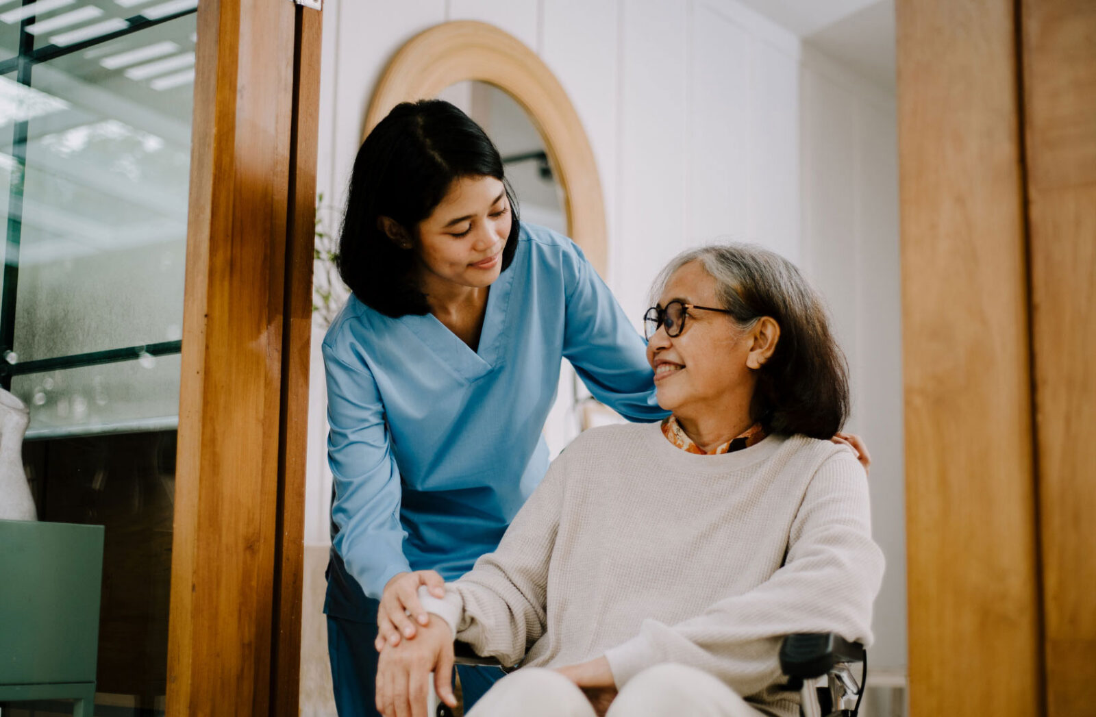 Caregiver and elderly woman sharing a warm moment.